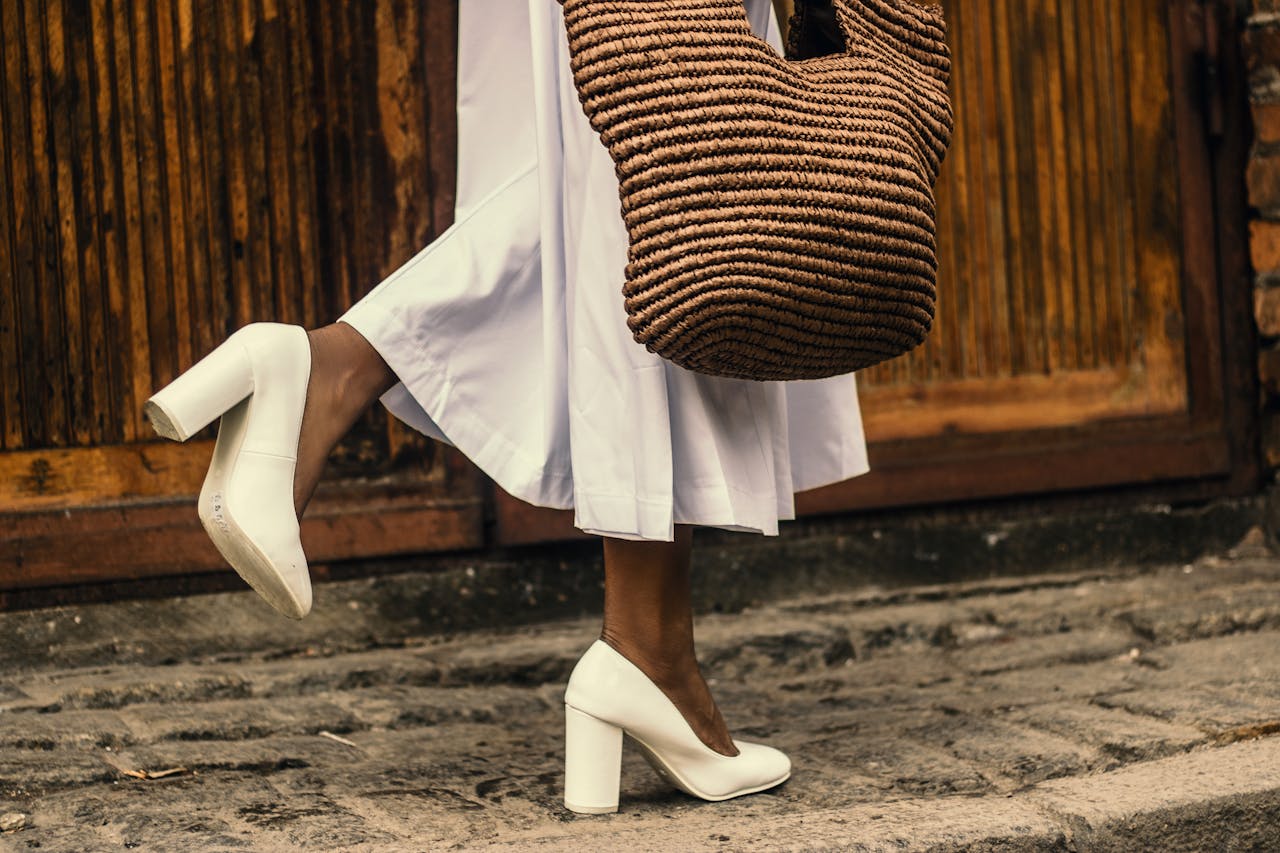 Woman Wearing White Dress and White High-heeled Shoes While Walking on Sidewalk